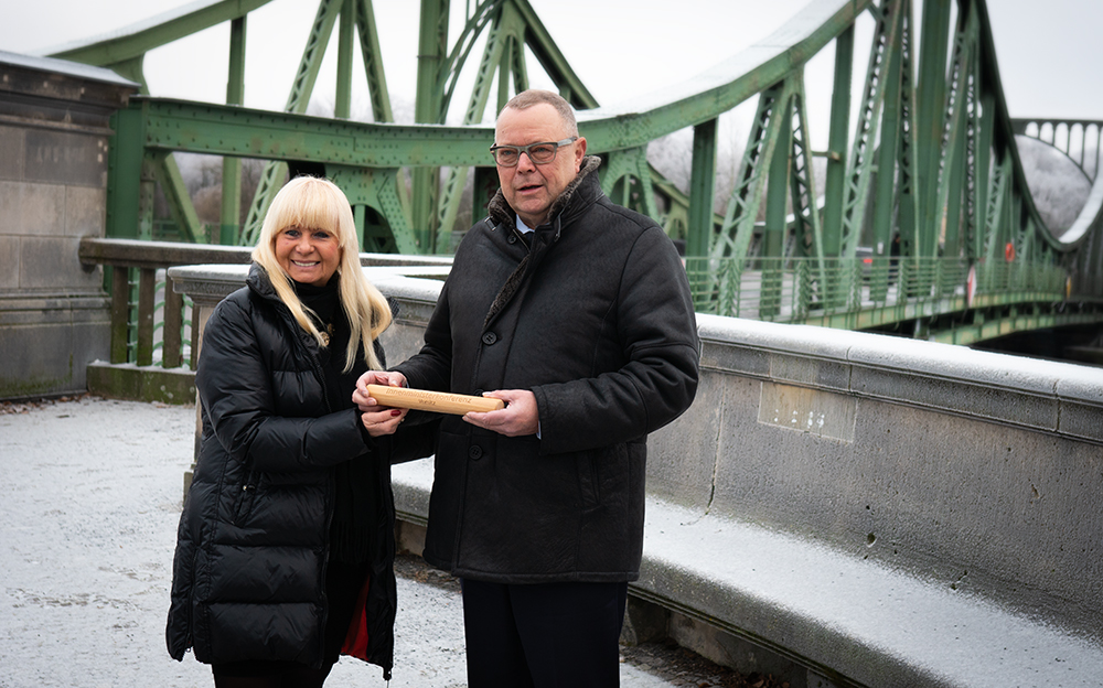 Bild: Foto von Innenminister Stübgen und Innensenatorin Spranger bei der symbolischen Staffelstabübergabe an der Glienicker Brücke in Potsdam